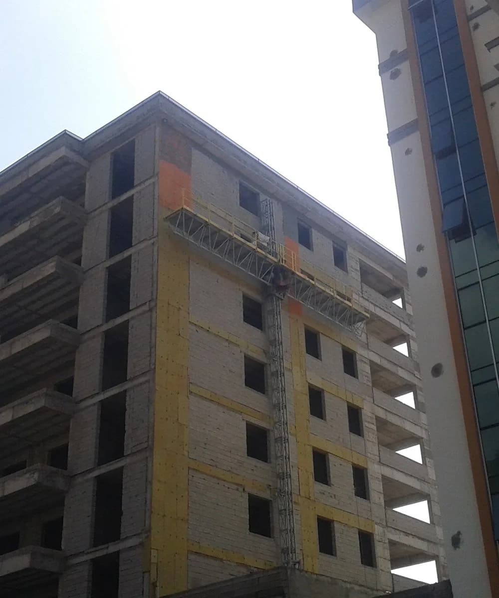 Bina cephesine ankrajlanmış tek kule cephe asansörü ve çalışma platformu